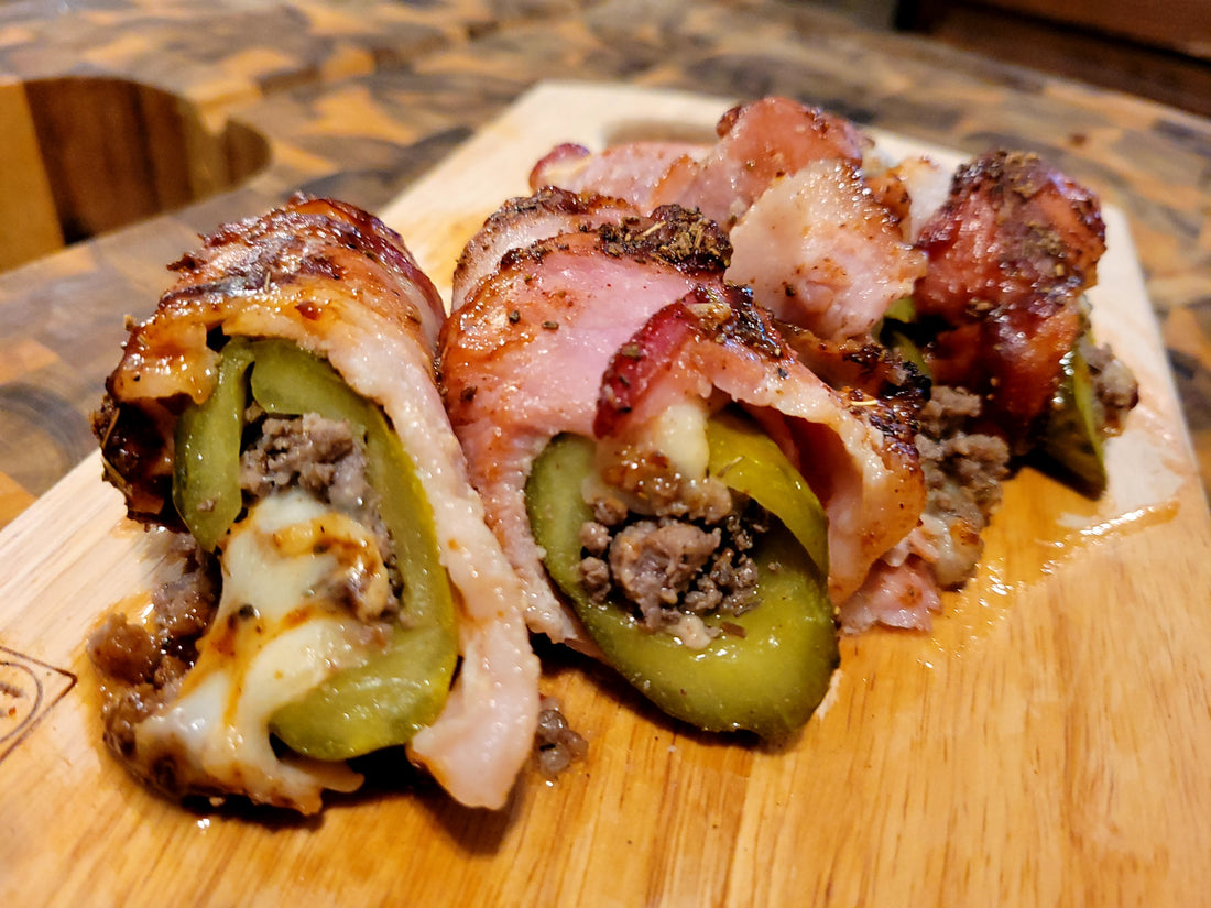 image of a pickle wrapped in bacon stuffed with meat and cheese.